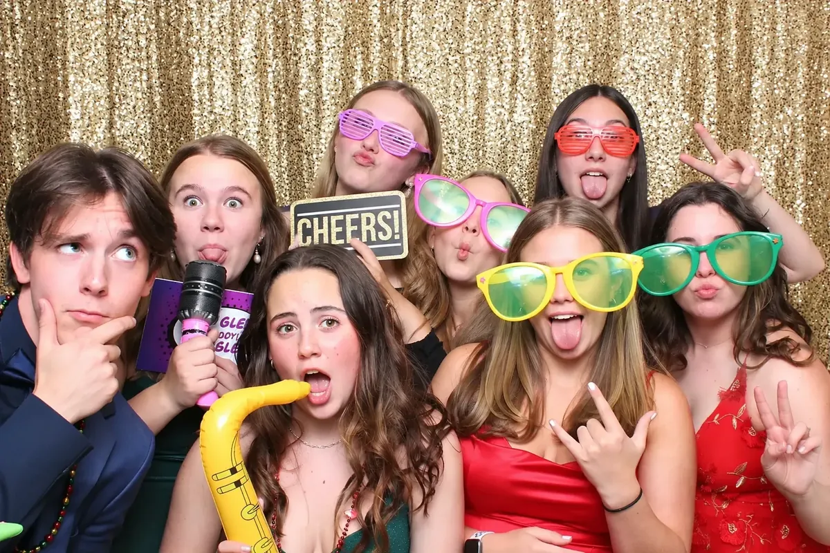 Guests in giant glasses at a sequin backdrop