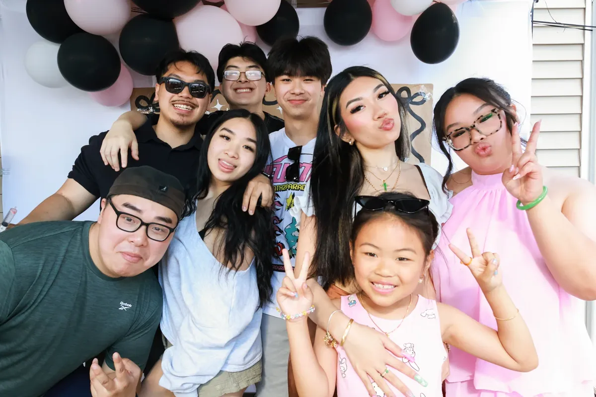Friends posing in front of pink and black balloons